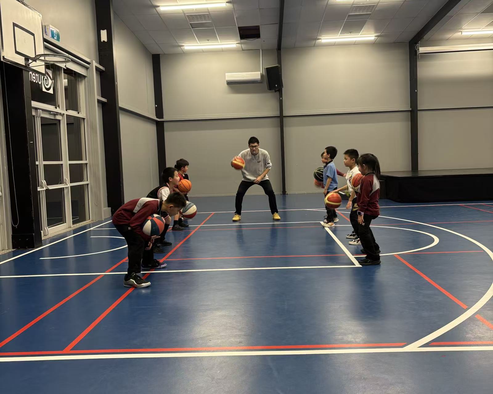 Coach facing a line of players dribbling on the court